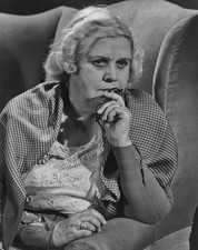 An old woman holding a pair glasses looking thoughtful 1940's Old Photo picture