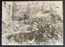 Romantic mood Flowers Handsome lone man lying in grass Bare torso photo Gay Int picture