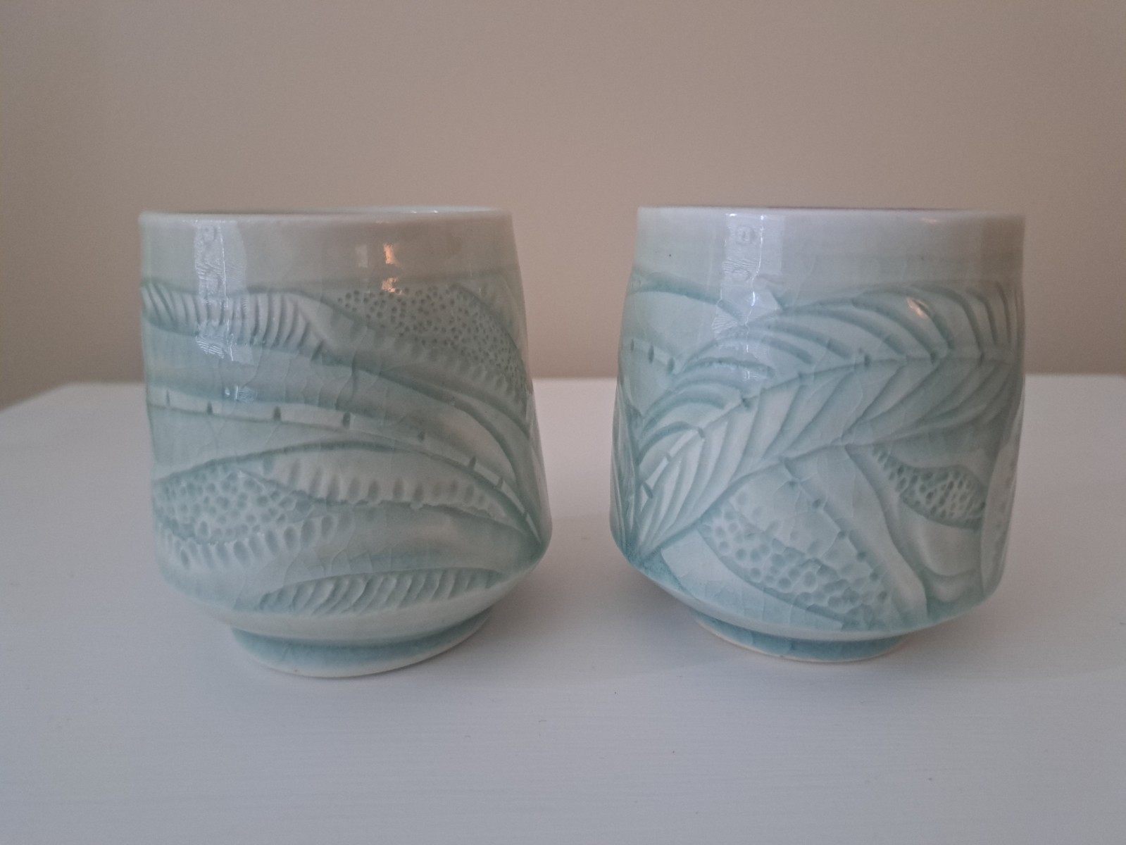 Vintage. Two matching Elaine Coleman carved cups with celedon glaze.