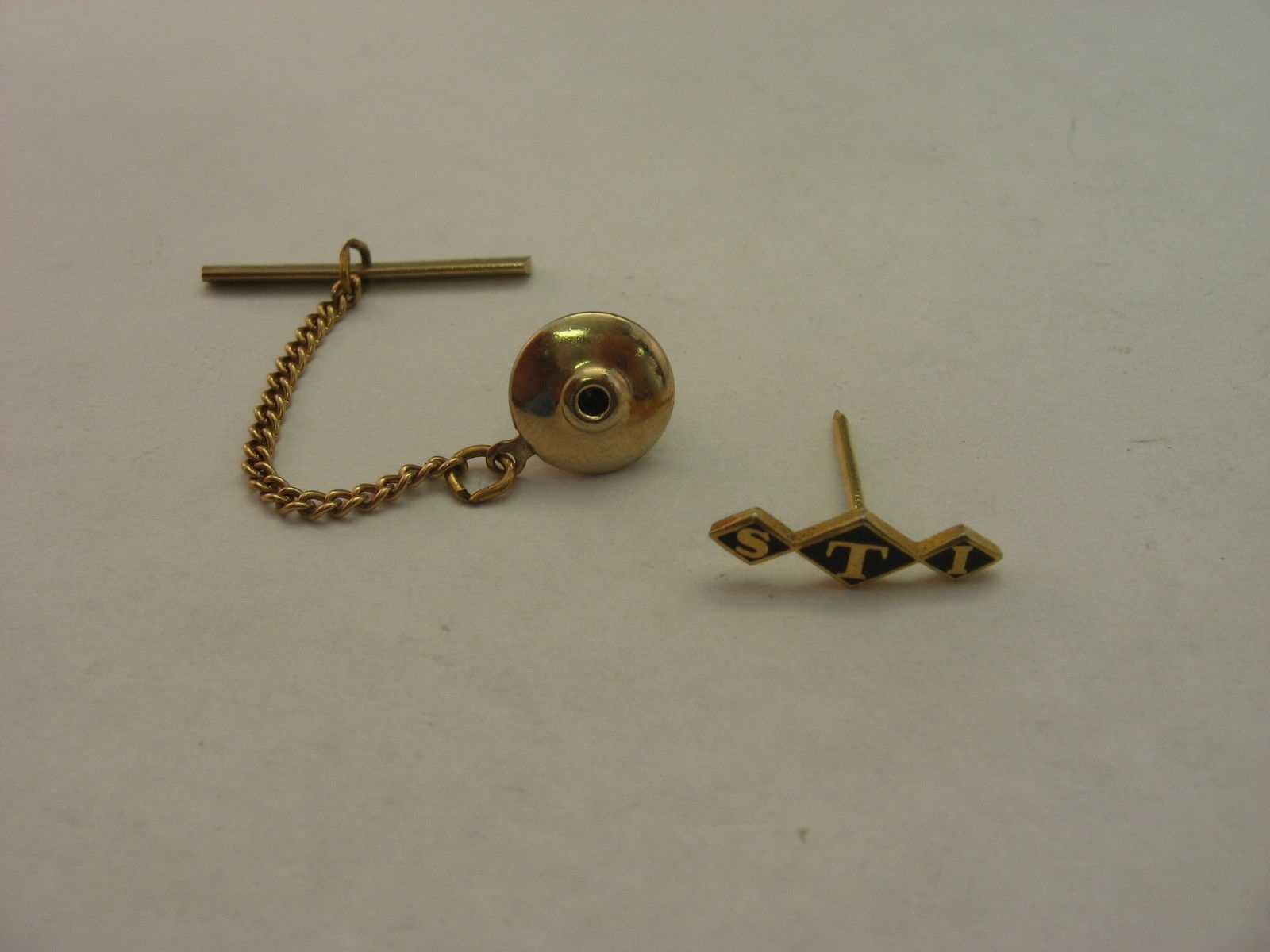 Vintage STI Logo Tie Tack Pin Gold Tone Black Enamel Corporate Advertising