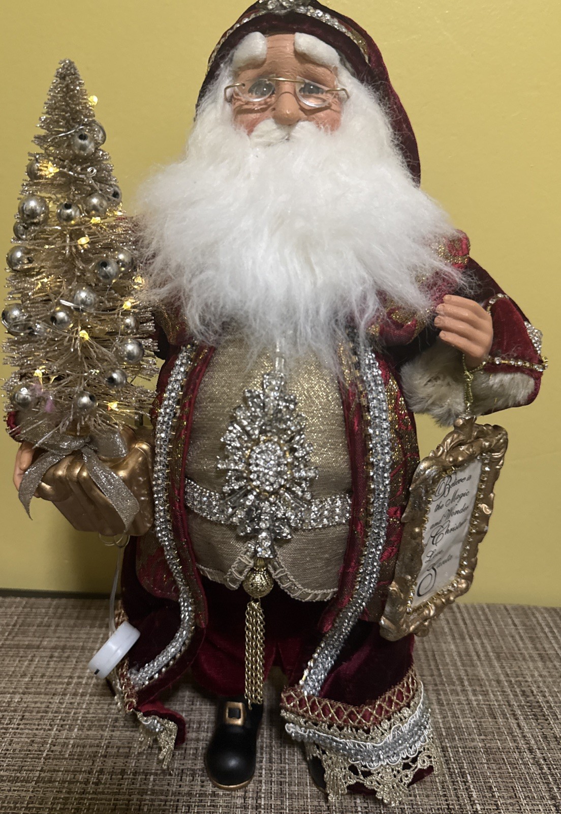 Santa Claus figure in red robe by Karen Didion with light up Christmas Tree