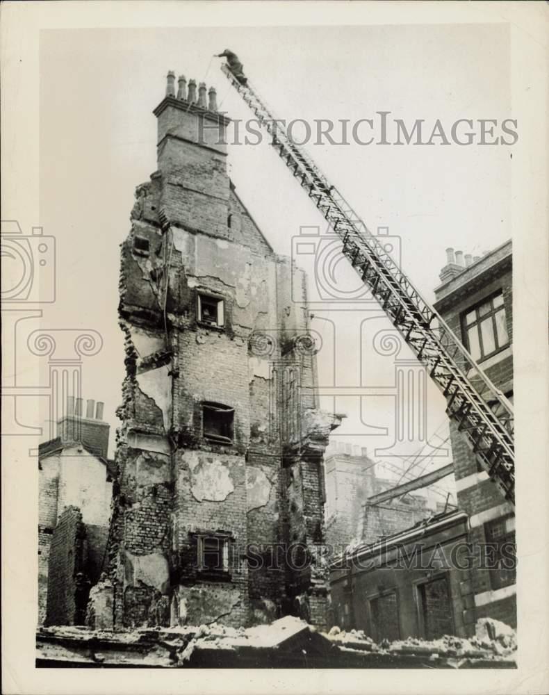 1941 Press Photo Worker prepares to pull down building bombed in World War II