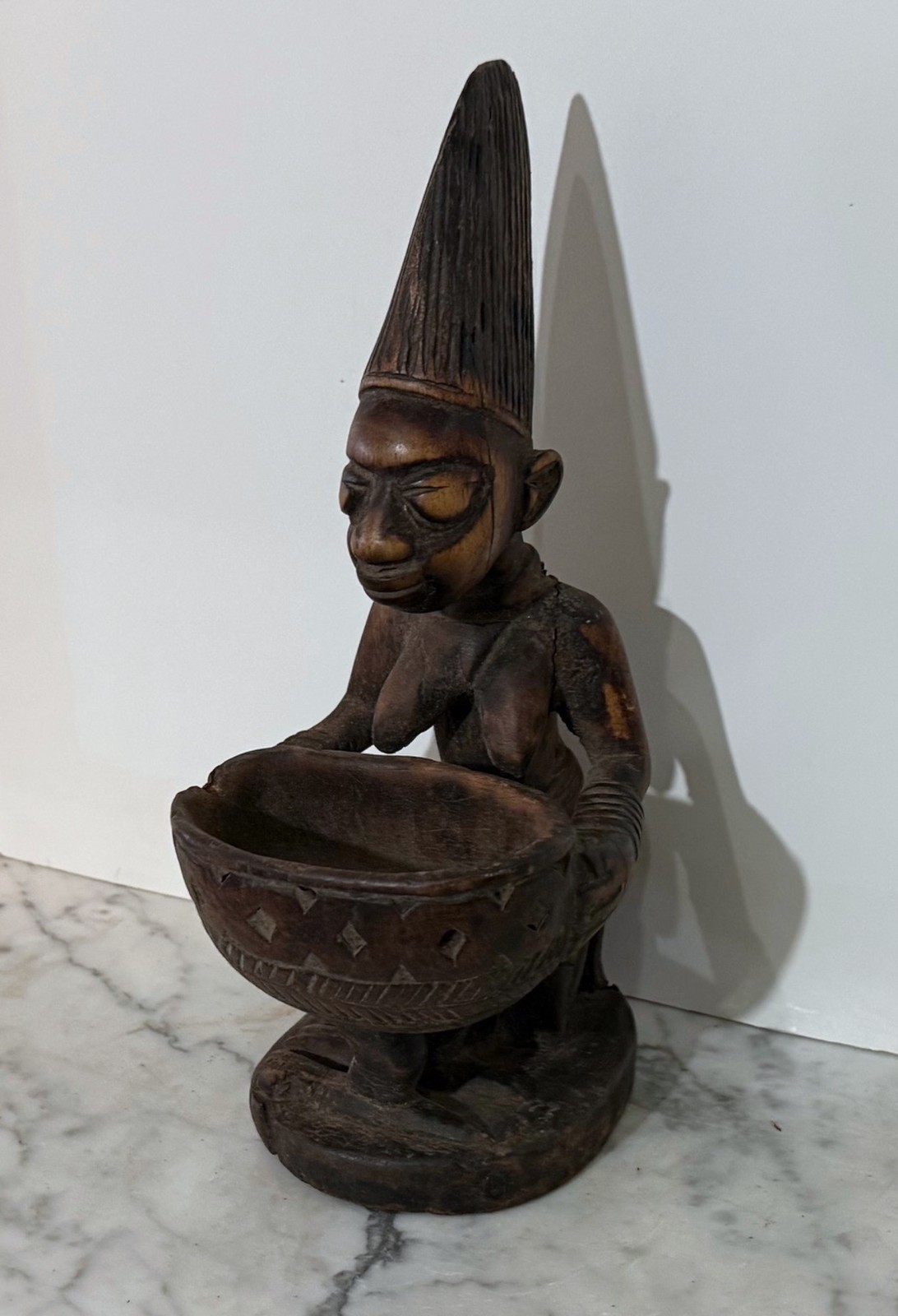 YORUBA PEOPLE CARVED WOOD STATUE OF A KNEELING FEMALE WITH AN OFFERING BOWL