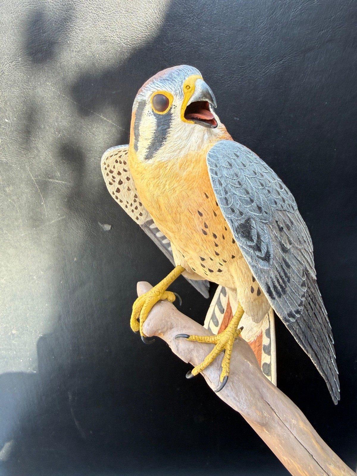 Wood carving of Kestrel on a branch