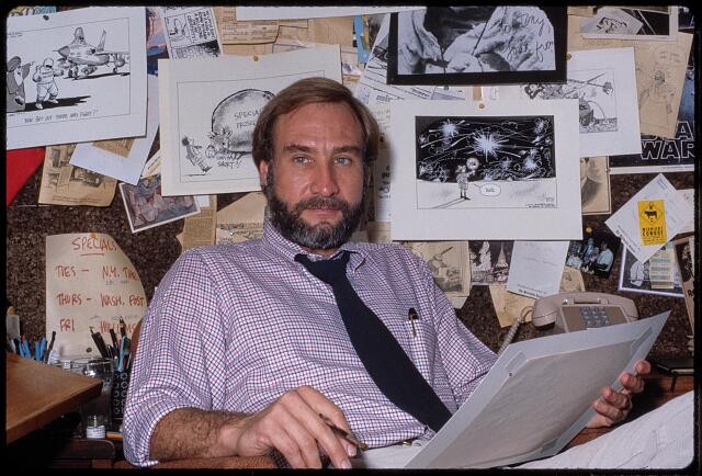 Photo:Tony Auth cartoonist 1980s working in front of sketches of cartoons