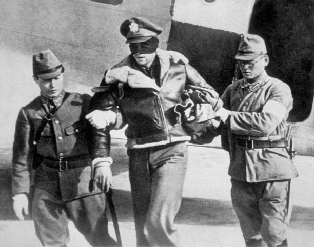 An American airman who took part in a raid over Tokyo is led away - Old Photo